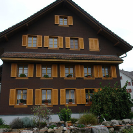 Holzhaus mit frisch gestrichenen Fensterläden